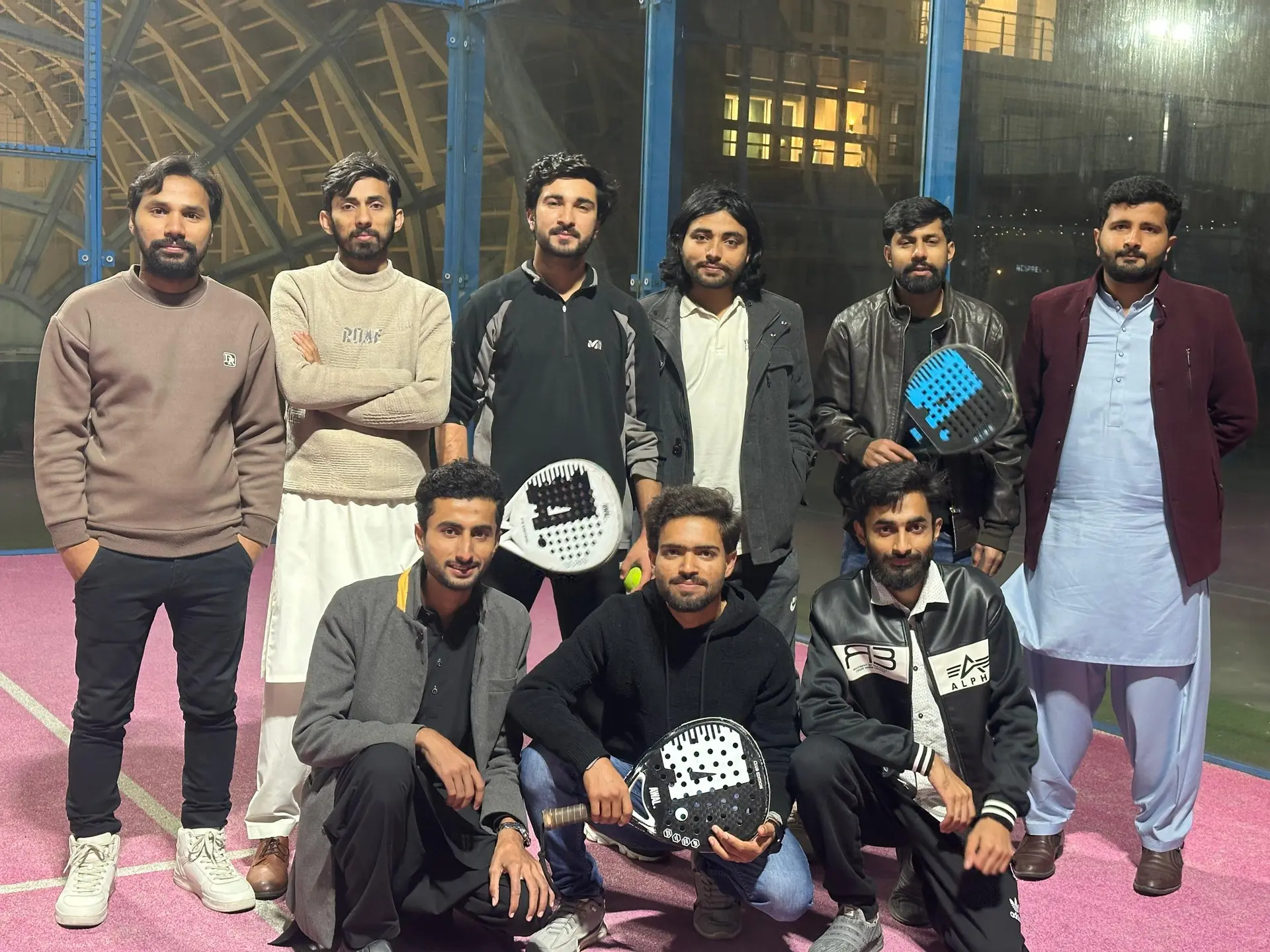 Team members with padel rackets after a match