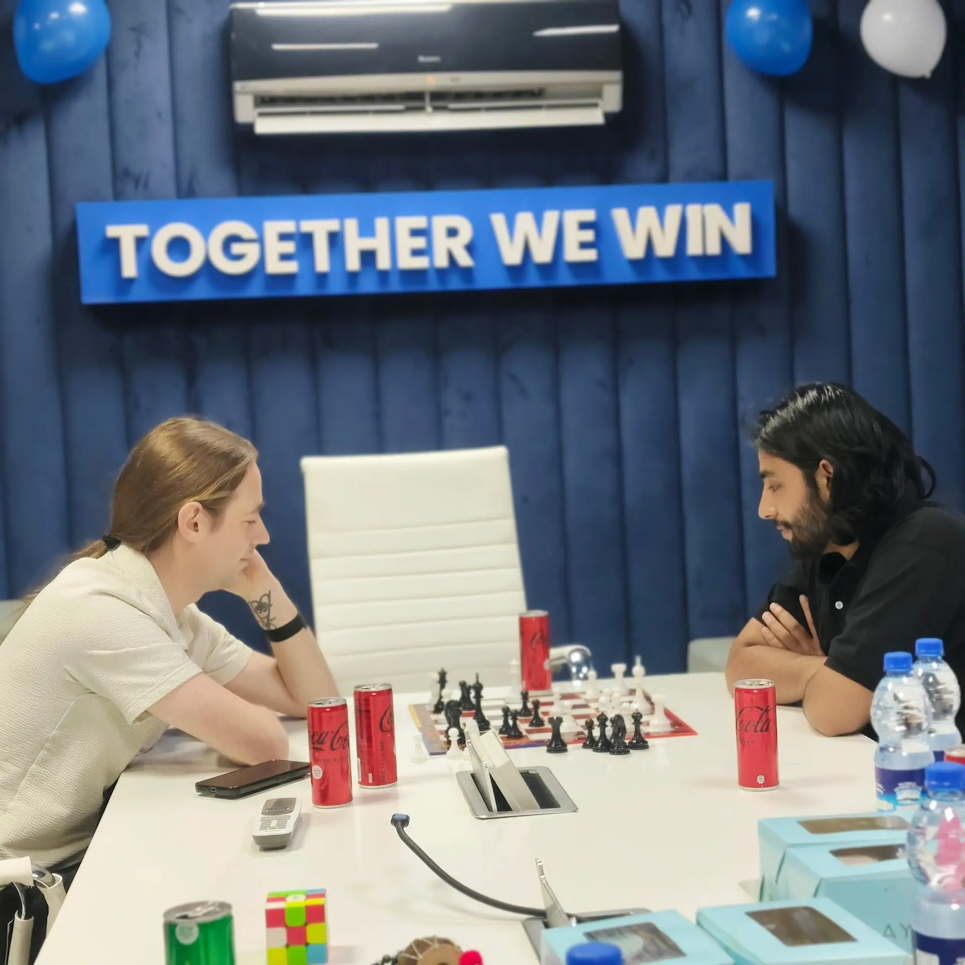 Colleagues playing chess in the Together We Win meeting room