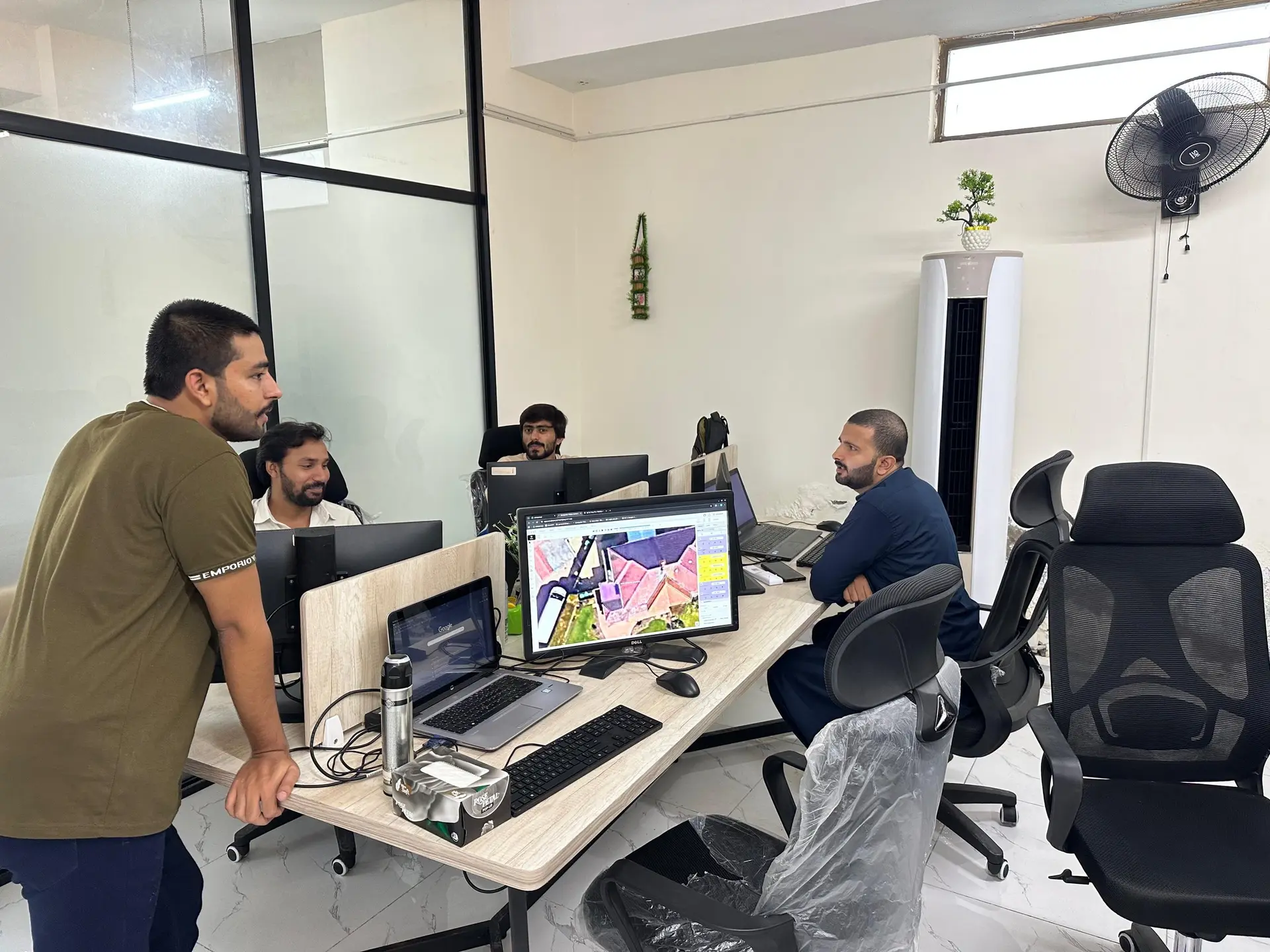Engineers at their desks with a solar layout on screen