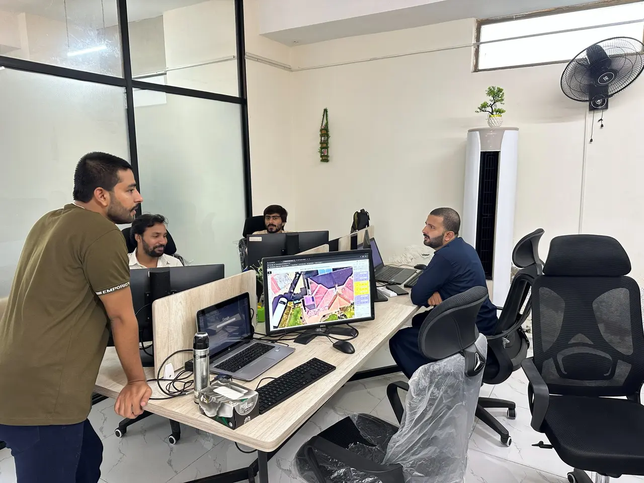 Engineers in Lahore reviewing a solar roof layout on a large monitor
