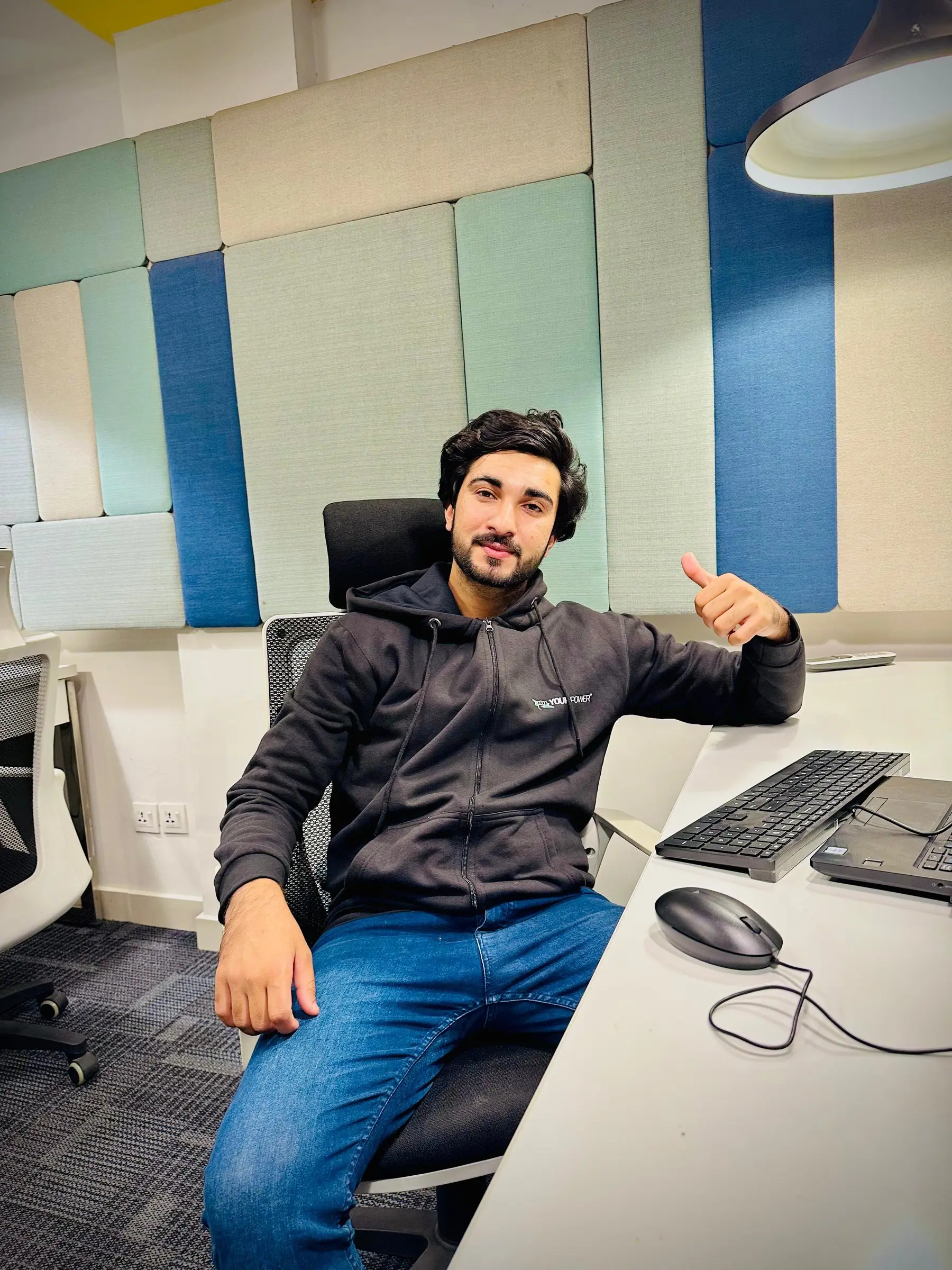 An engineer giving a thumbs up from his workstation